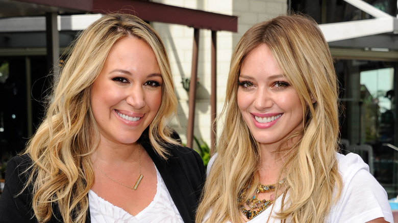 Haylie Duff and HIlary Duff posing outdoors