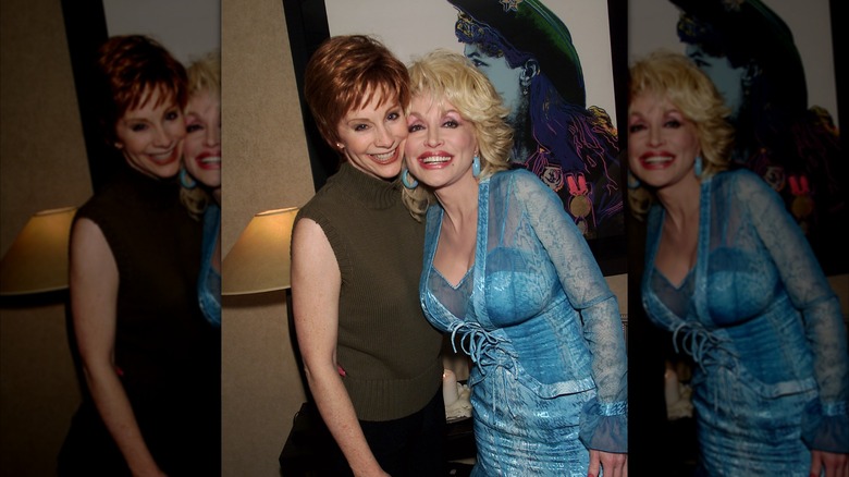 Reba McEntire and Dolly Parton smiling for a photo