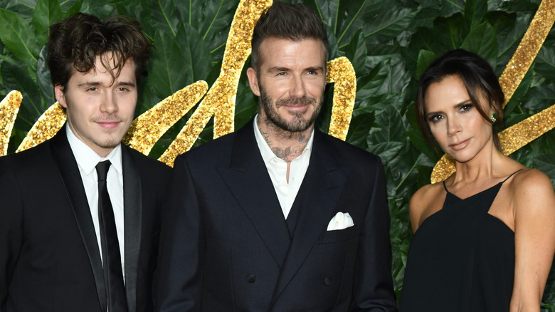 Brooklyn Beckham with his parents David and Victoria Beckham in 2018