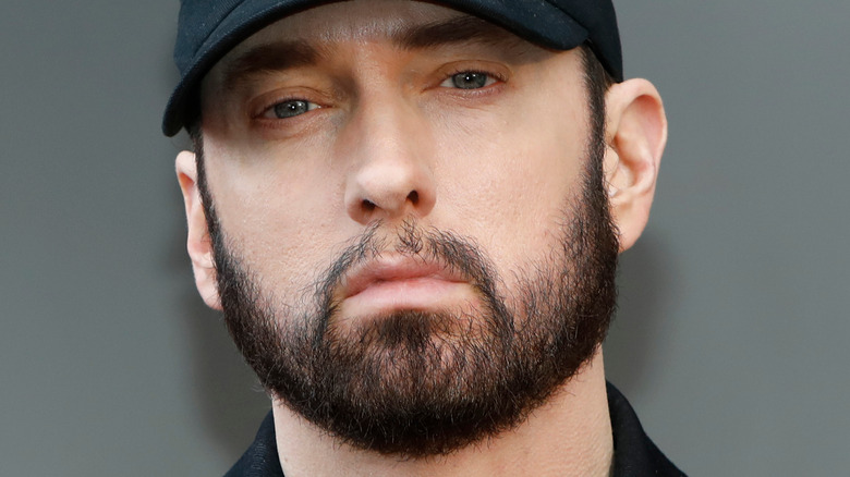 Eminem staring with full beard and hat