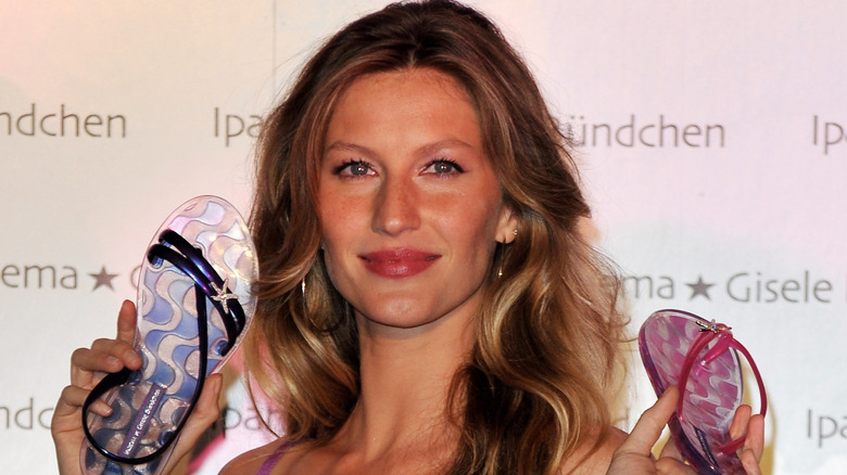 Gisele Bundchen holding up flip-flops