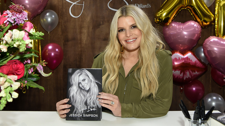 Jessica Simpson holding her memoir