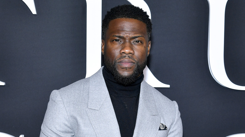 Kevin Hart posing in a gray jacket