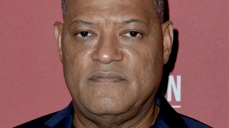 Laurence Fishburne in front of red background