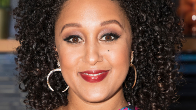 Tamera Mowry smiling with curly hair