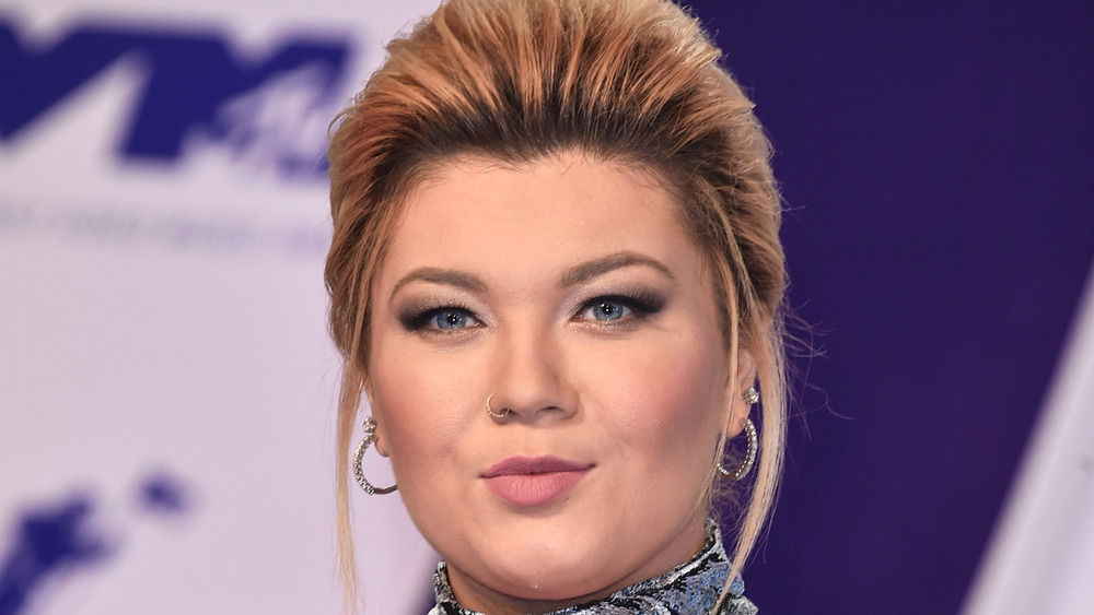 Amber Portwood poses on the red carpet with her red hair in an up-do