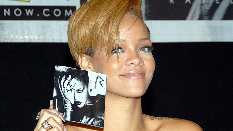 Rihanna holding her "Rated R" album