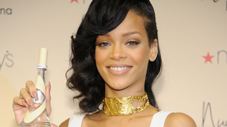Rihanna holding a bottle of her perfume