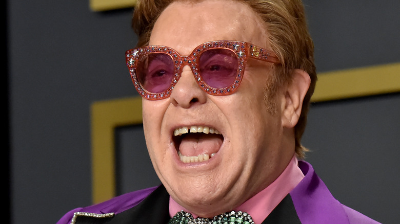 Elton John posing at a red carpet event