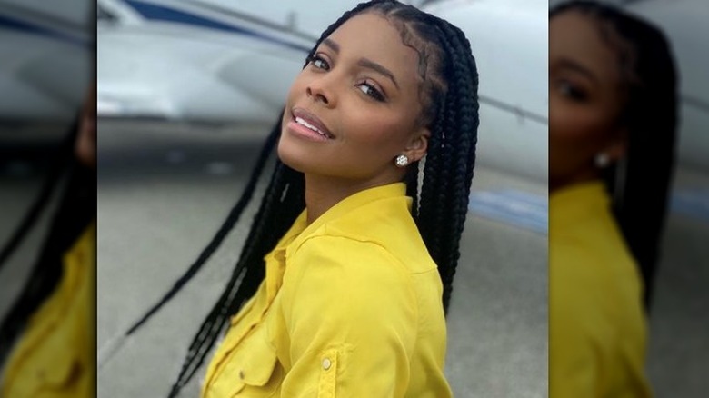 Angel Love Davis poses in front of a plane