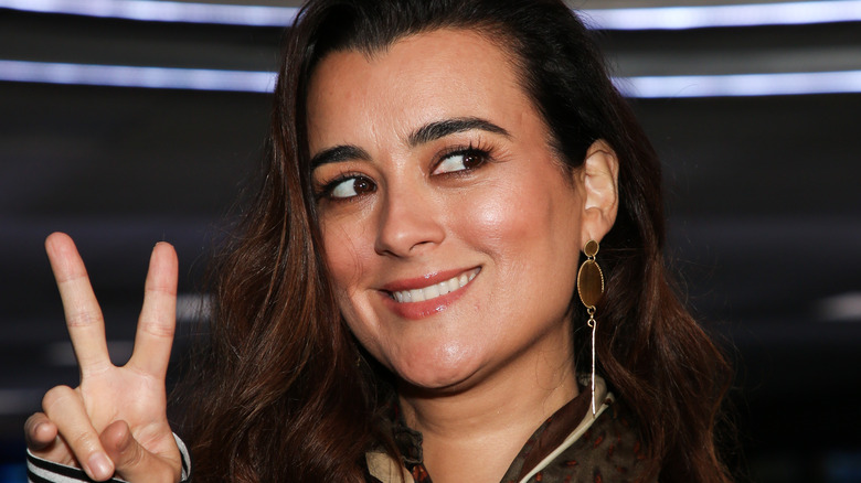 Cote de Pablo smiling with peace sign