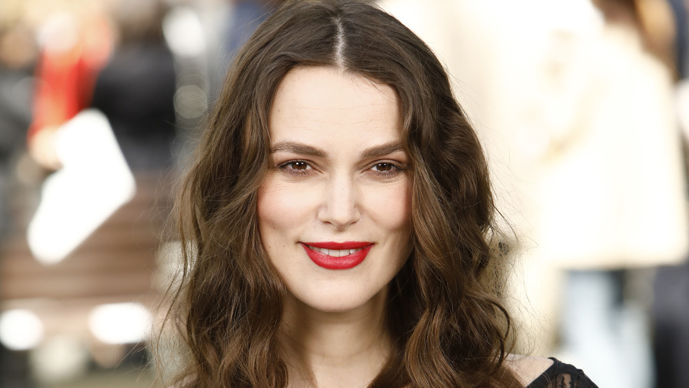 Keira Knightley smiles and wears red lipstick