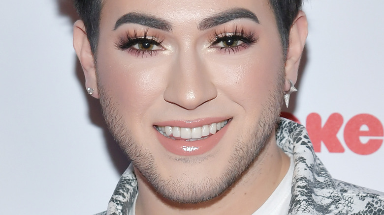 Manny MUA smiling with a glam look