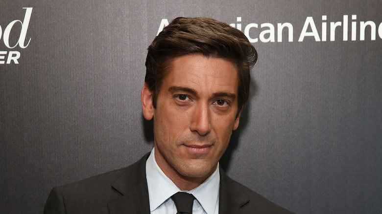 David Muir poses in a suit