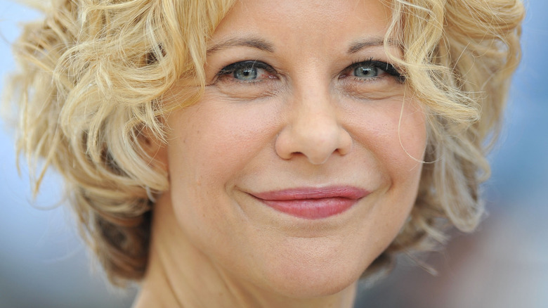 Meg Ryan poses with short, curly hair.