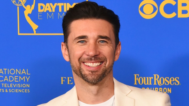 Billy Flynn smiling in beige suit