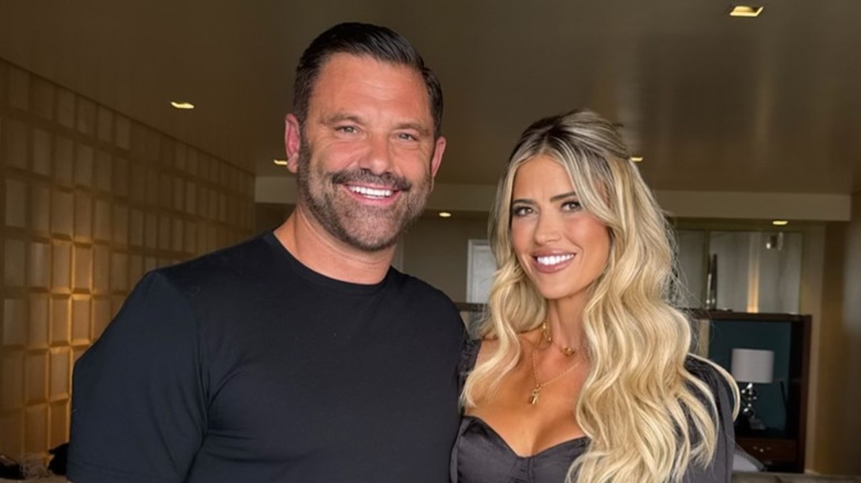 Christopher Larocca and Christina Haack light up with wide smiles against a posh background