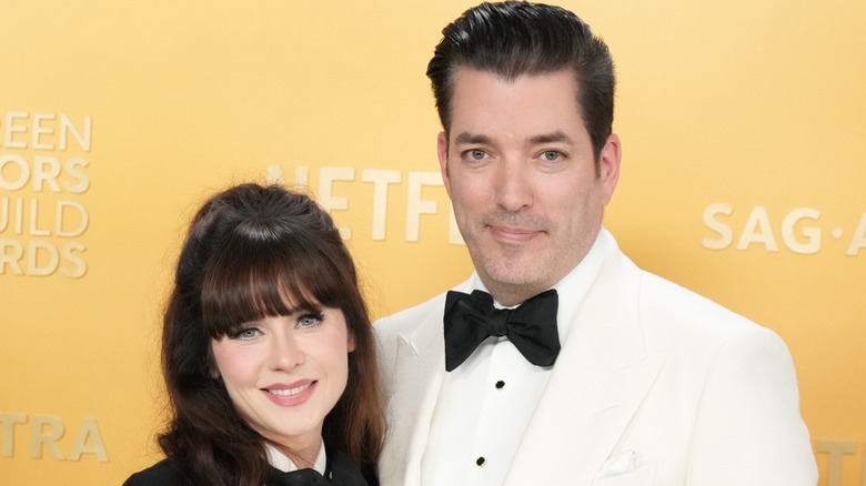 Jonathan Scott and Zooey Deschanel pose in coordinated outfits on the red carpet