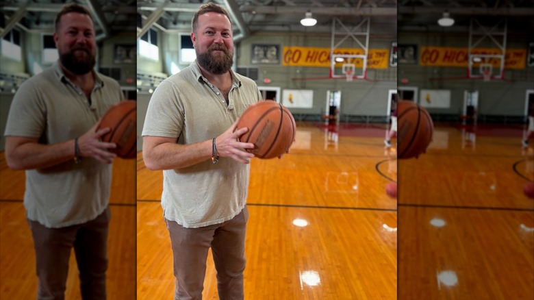 Ben Napier holding a basketball on an indoor basketball court.