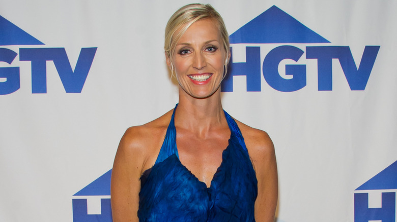 Candice Olson posing in front of the HGTV logo