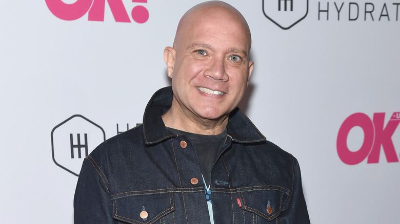 Eric Eremita wearing a denim jacket while posing at an event