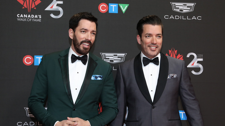 Drew and Jonathan Scott posing together in tuxedoes.