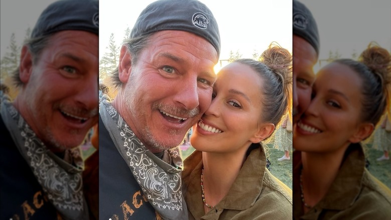 Ty Pennington and wife Kellee Merrell smiling in front of a sunset.