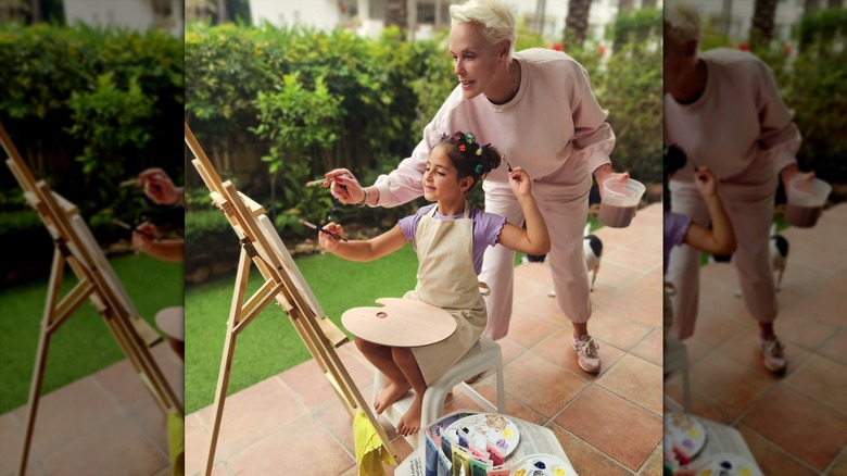 Brigitte Nielsen painting outside with her daughter Frida