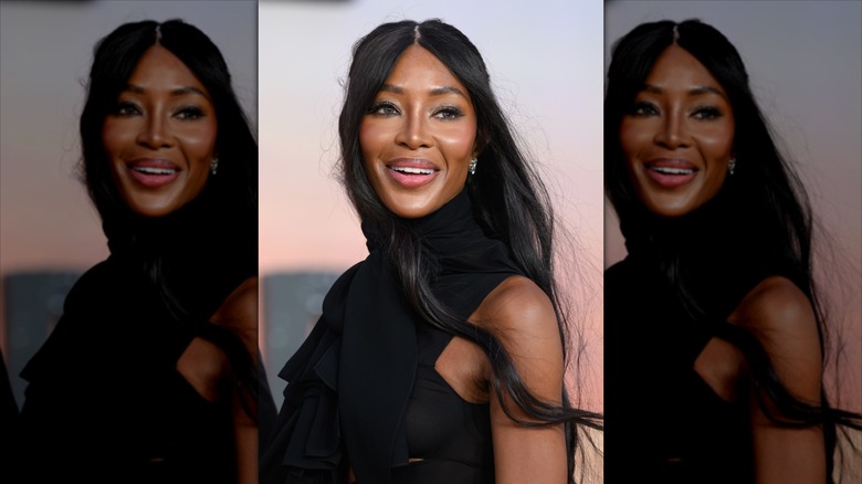 Naomi Campbell in a black dress, smiling