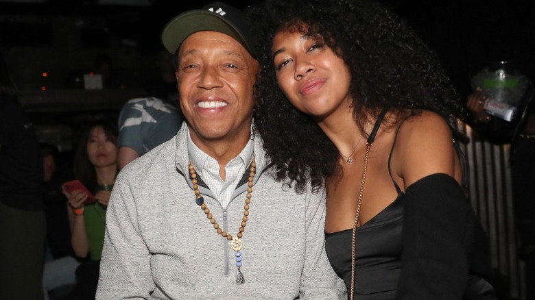 Aoki Lee Simmons leans on a smiling Russell Simmons.