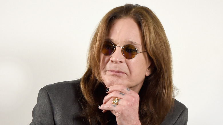 Ozzy Osbourne touching his chin
