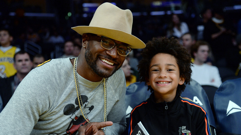 Taye Diggs and his son smiling at a basketball game
