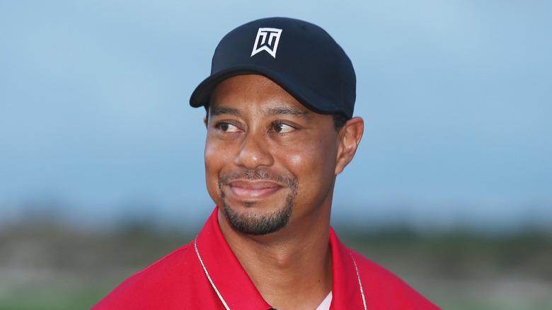 Tiger Woods on the links in a red polo and black cap