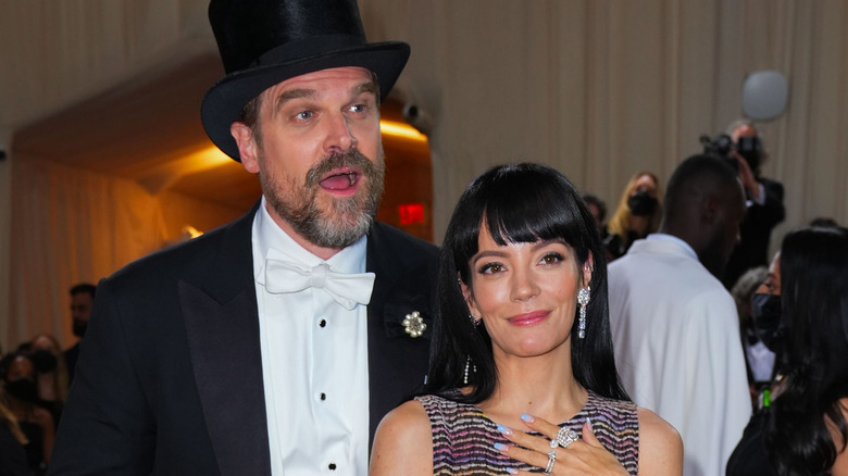 David Harbour wearing top hat, Lily Allen with hand on chest