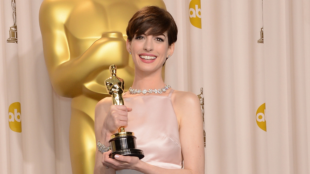 Anne Hathaway holding her Oscar award in 2013