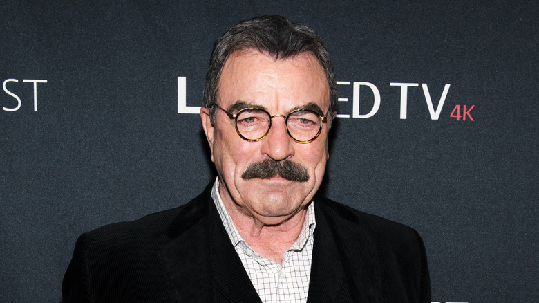 Tom Selleck poses in round-framed glasses