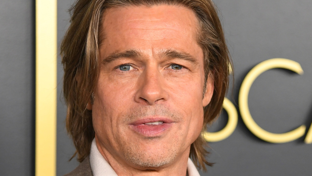 Brad Pitt posing on the red carpet with long hair