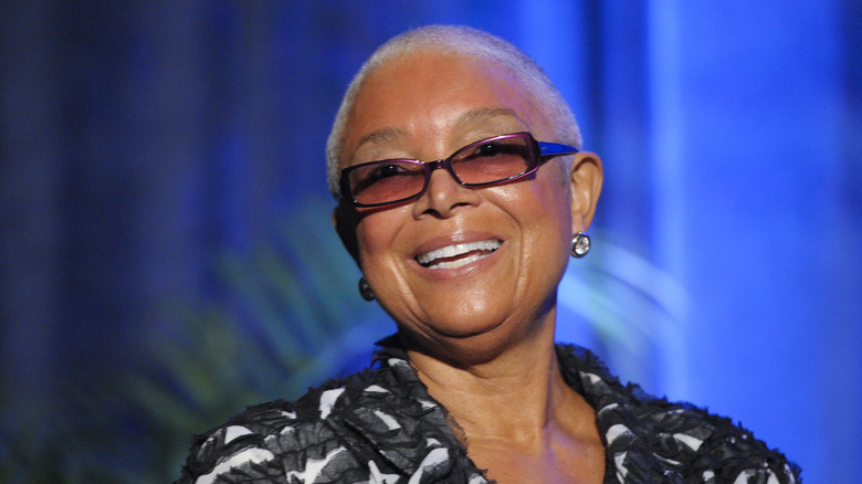 Camille Cosby smiling and wearing sunglasses
