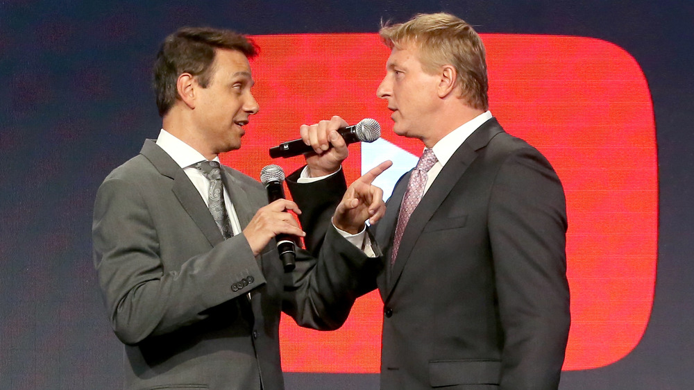 Ralph Macchio & William Zabka holding mics talking to each other