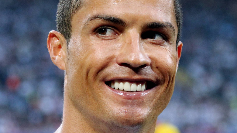 Cristiano Ronaldo smiles on a soccer field 