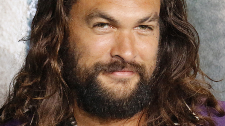 Jason Momoa smiling on red carpet