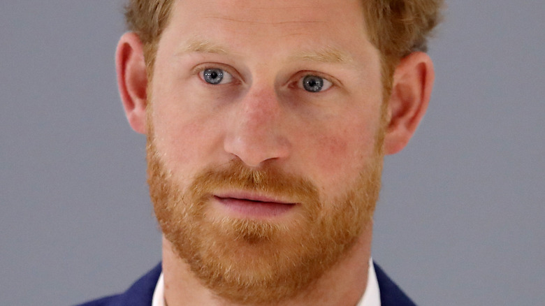 Prince Harry poses in a navy suit.