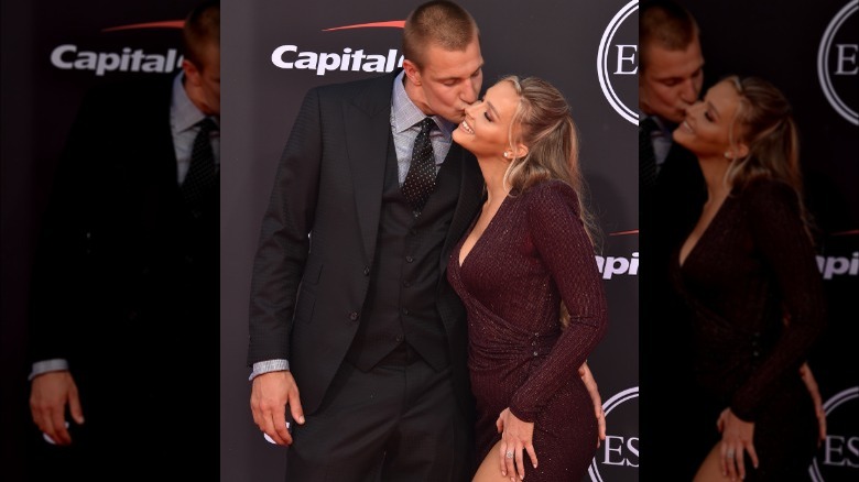 Rob Gronkowski and Camille Kostek kiss on a red carpet