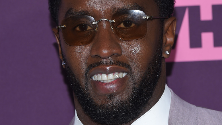 Diddy smiles in shades and a silver suit