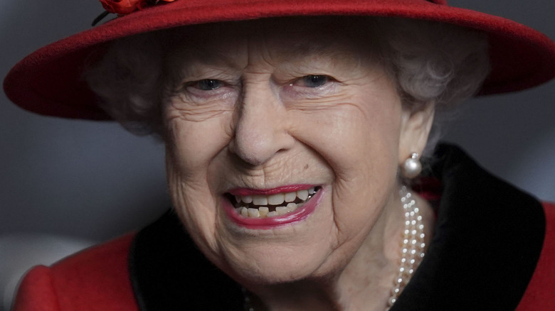 Queen Elizabeth smiling in red hat