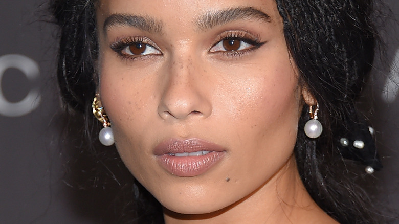 Zoe Kravitz with serious expression and pearl earrings on the red carpet