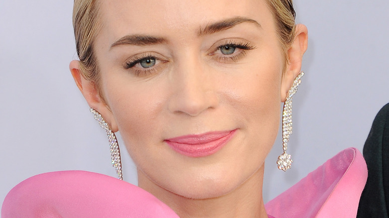 Emily Blunt looking at camera with slight smile and pink lipstick