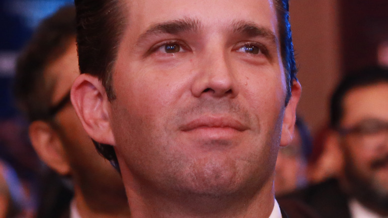 Donald Trump Jr. smiling and looking to side