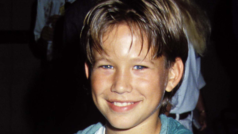 A young Jonathan Taylor Thomas smiling while posing at an event