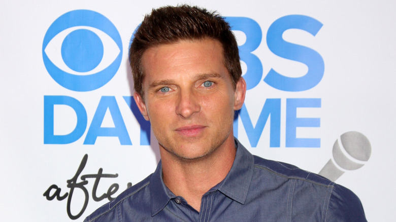 Steve Burton posing in a dark blue collared shirt.